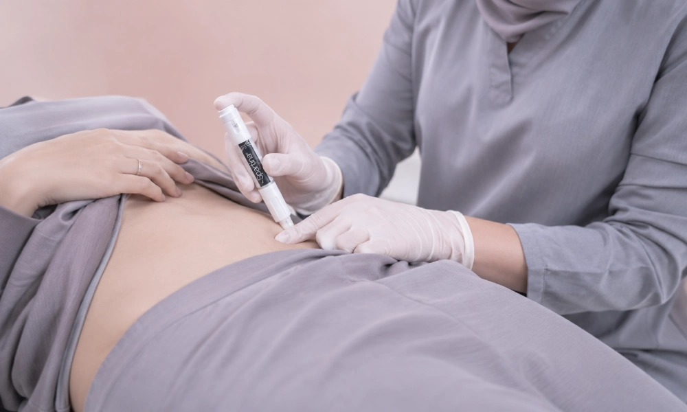 خانم دکتری در حال تزریق آمپول لاغری به شکم بیمار خانم